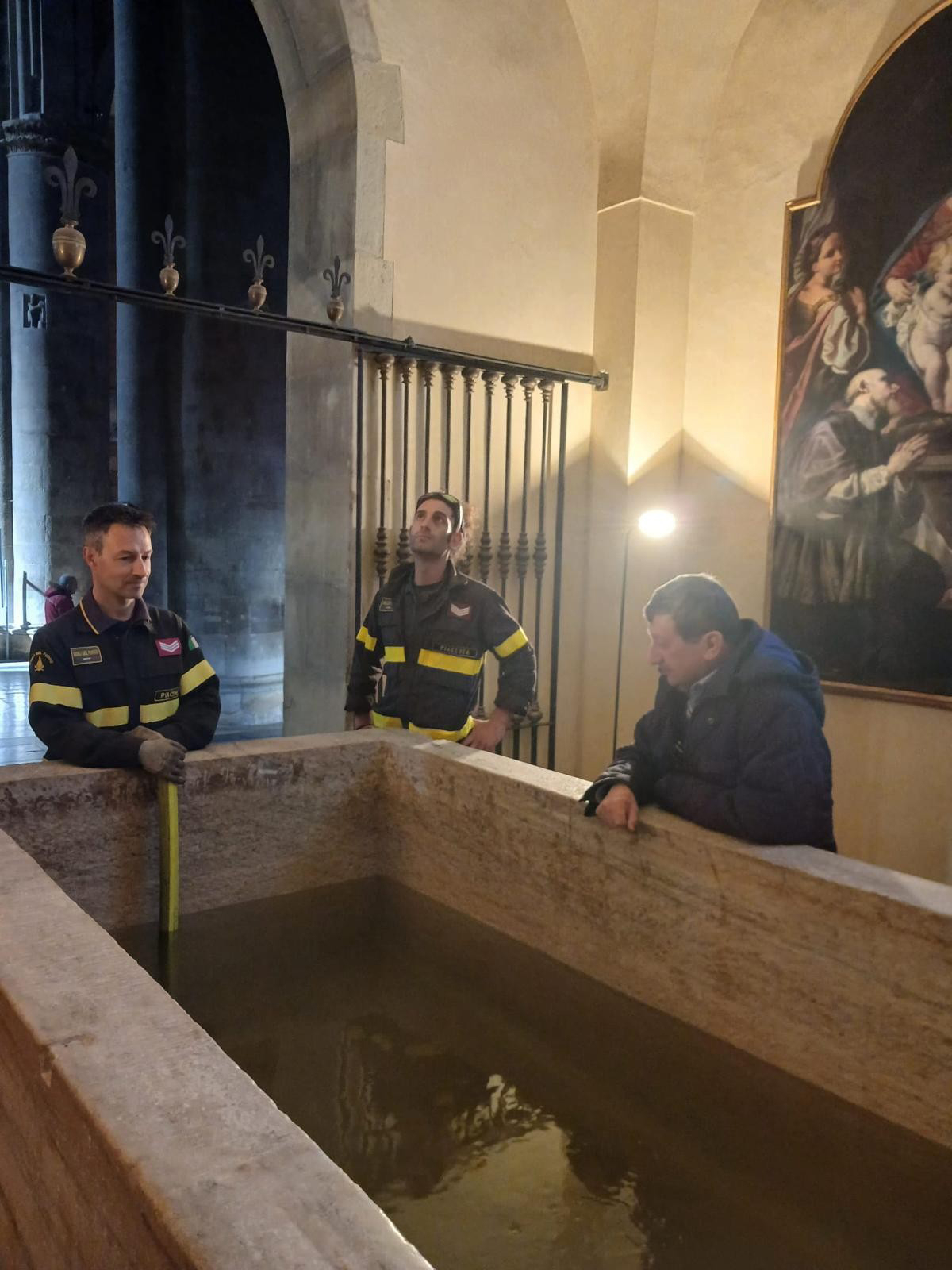 Le operazioni di riempimento del fonte battesimale dei duomo di Piacenza effettuate come ogni anno dai Vigili del Fuoco