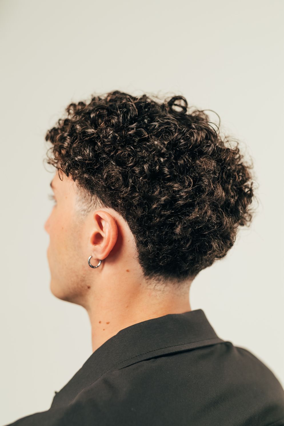 Blowout Taper: un look urbano e sartoriale per capelli ricci. Prodotto chiave: Crema Ricci Twist & Hold