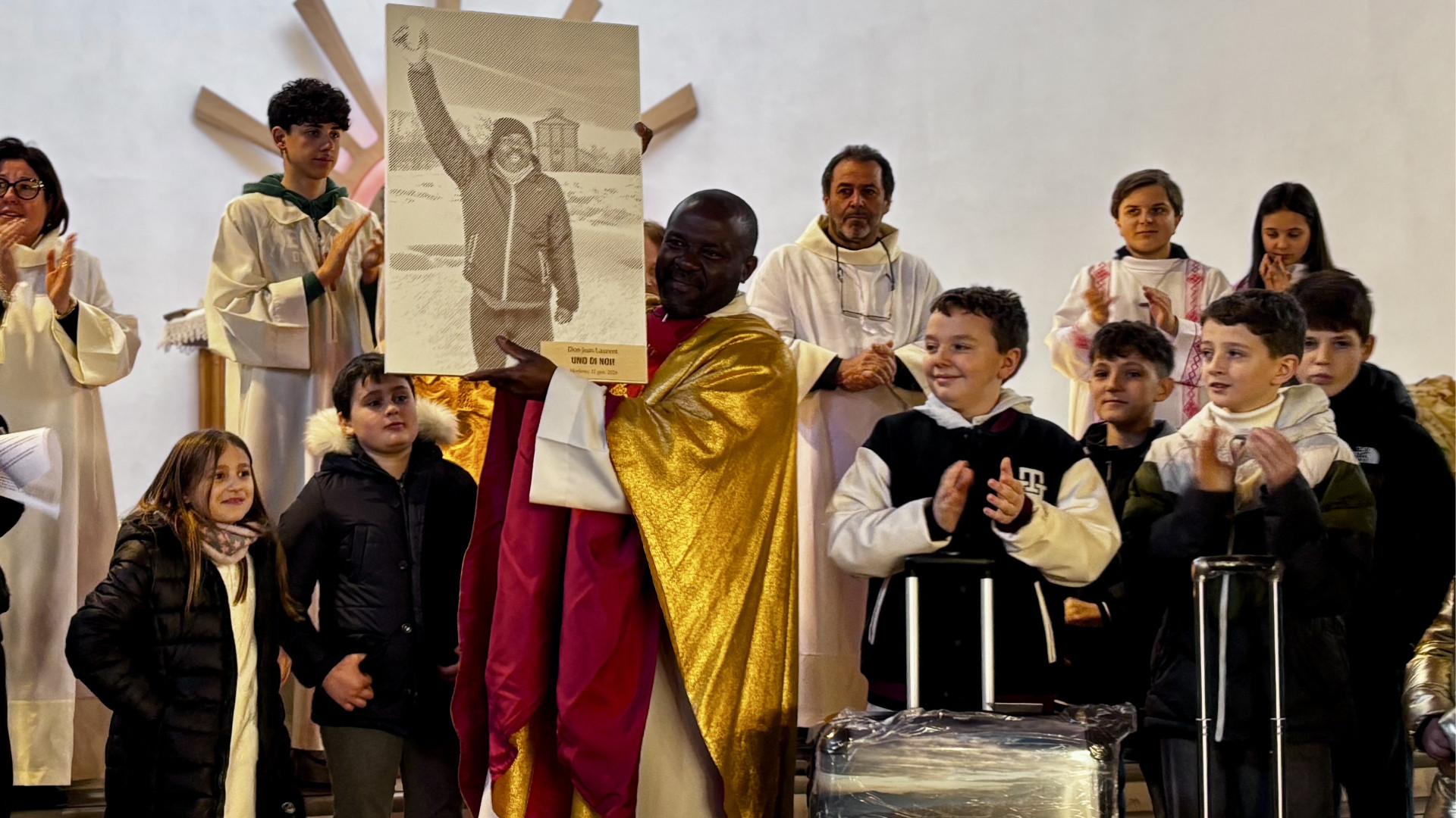 Don Jean Laurent Konango con il ritratto e le valigie a lui donate dalla comunità di Morfasso