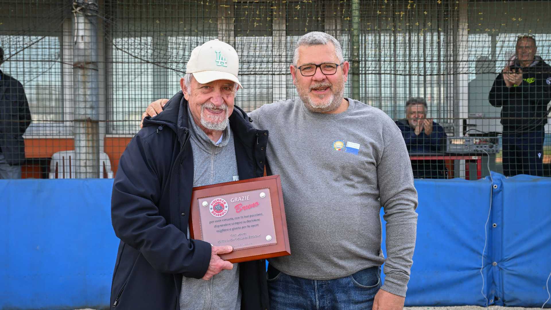 L'arbitro piacentino Bruno Frigeri (a sinistra) riceve una targa alla carriera (oltre 8 mila partite dirette) dal consigliere regionale Fibs, Mattia Forlani