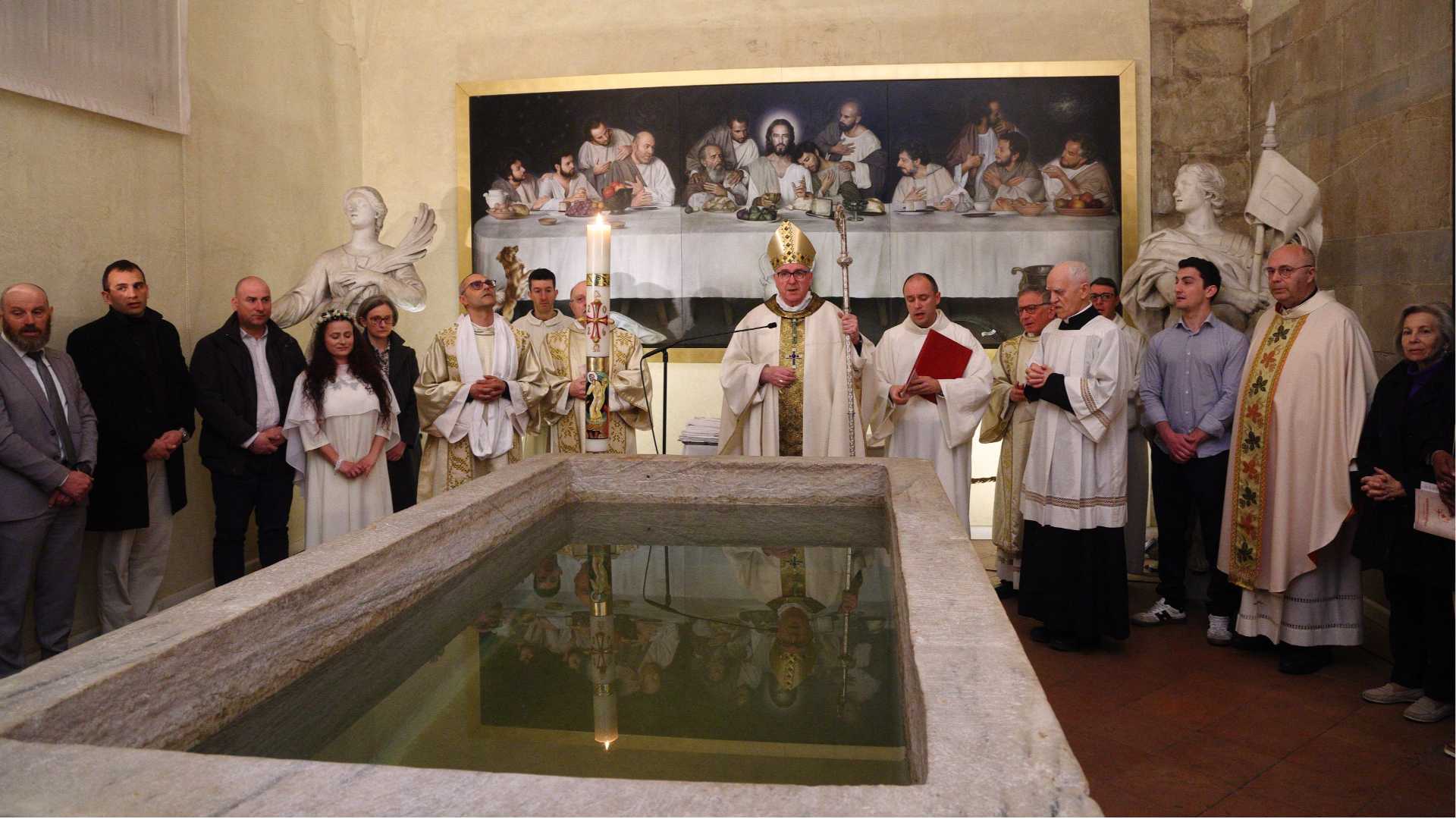 La celebrazione dei battesimi in Duomo con il fonte battesimale dove è evidente la linea dell’acqua calata in 24 ore