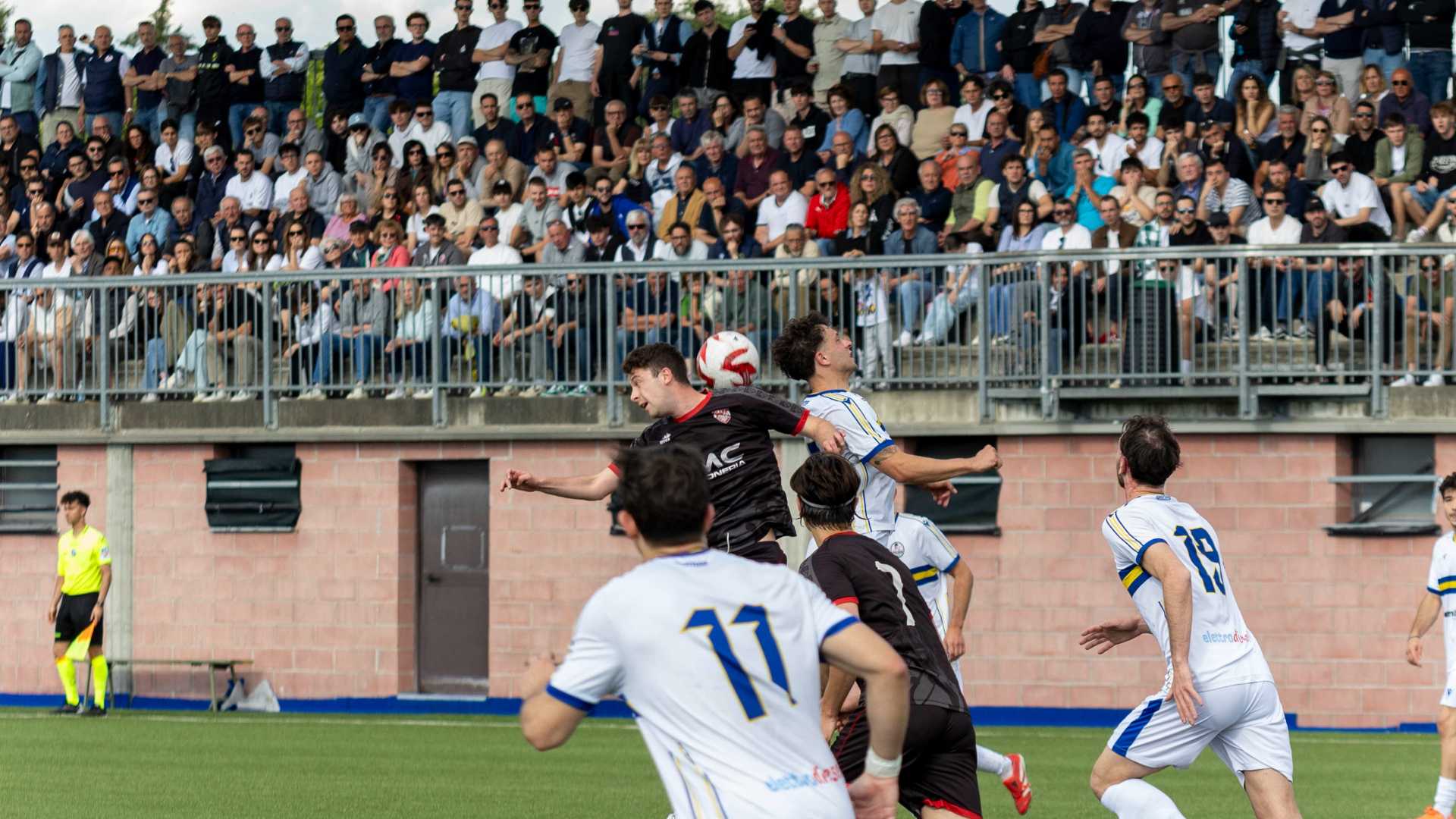Un'azione di Sporting Fiorenzuola-Ziano di fronte alla tribuna gremita del campo Bricchi