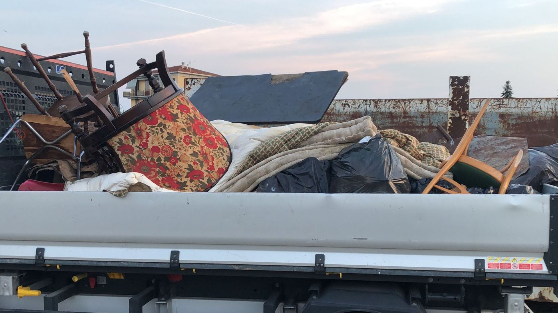 Tavolino, sedie, poltrone e materassi: un intero arredo abbandonato lungo l'Arda