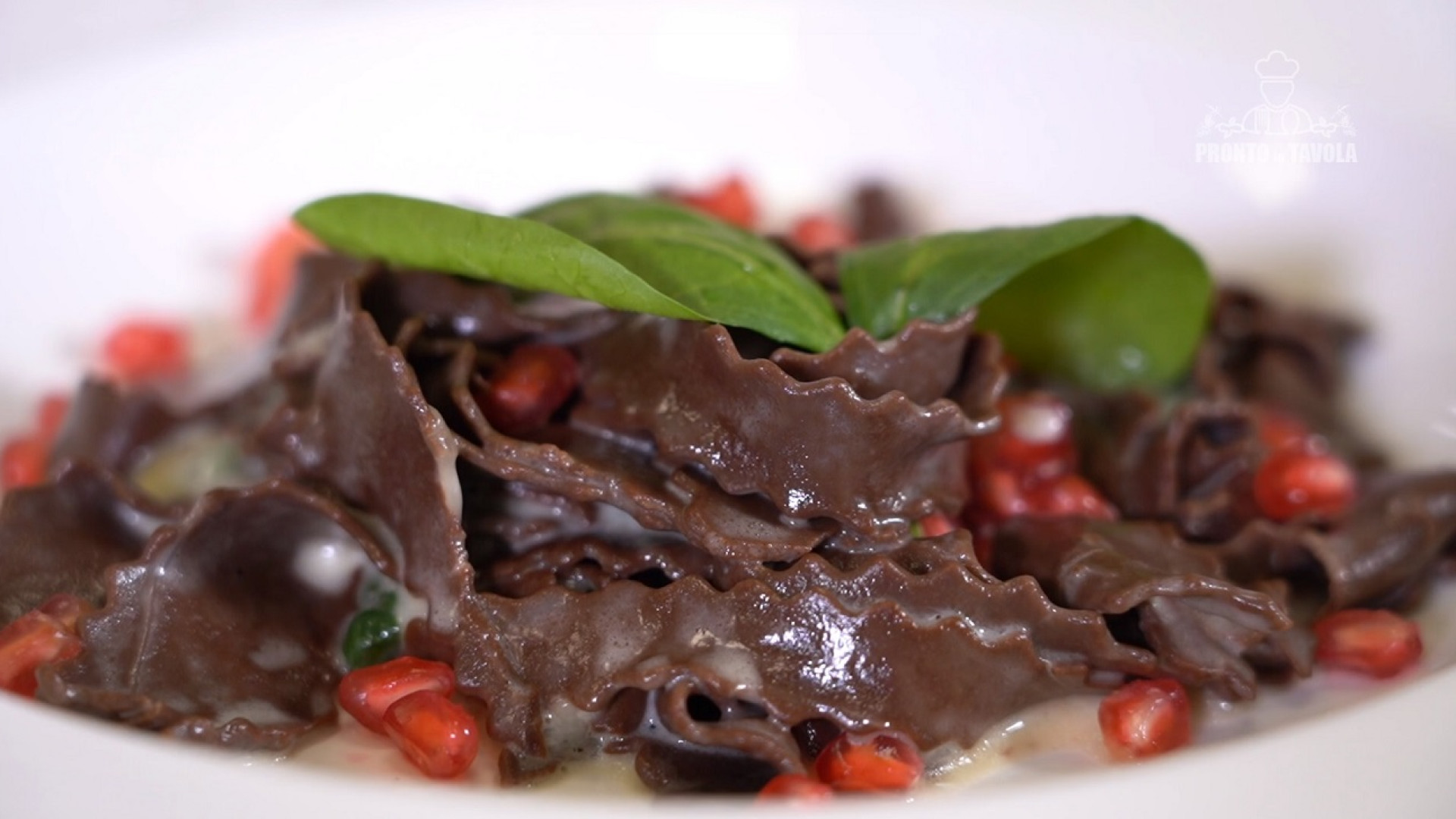 Reginette al cacao con salsa al taleggio, spinaci al salto e chicchi di melagrana