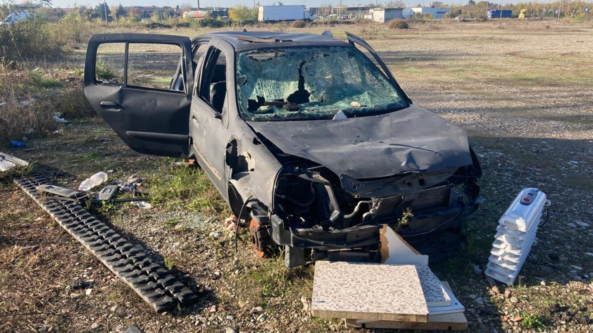 In via Martelli la carcassa di un'auto diventa una mini-discarica: "Così da due anni"