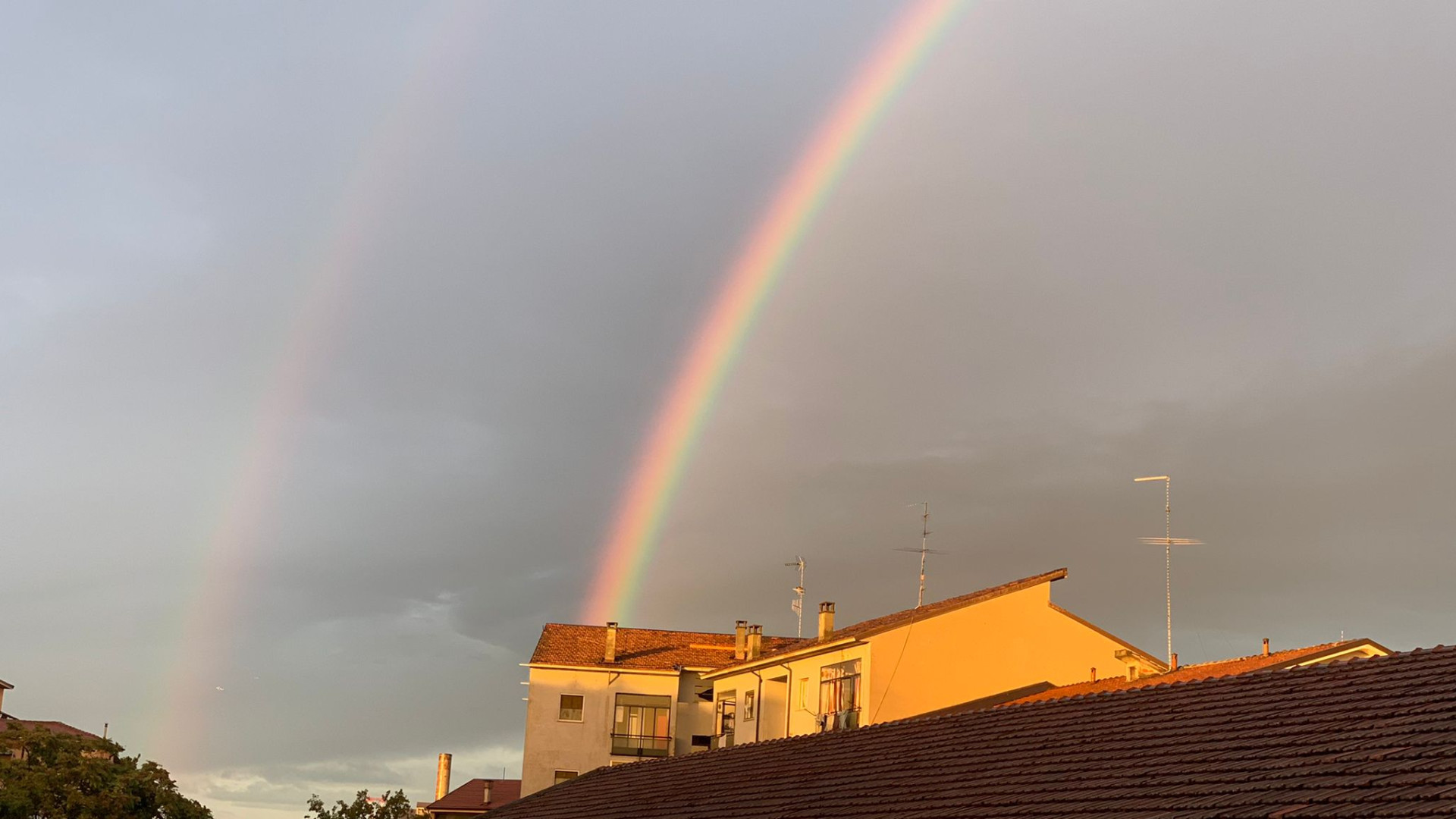 Dopo una giornata di pioggia il cielo si squarcia e compare un doppio arcobaleno