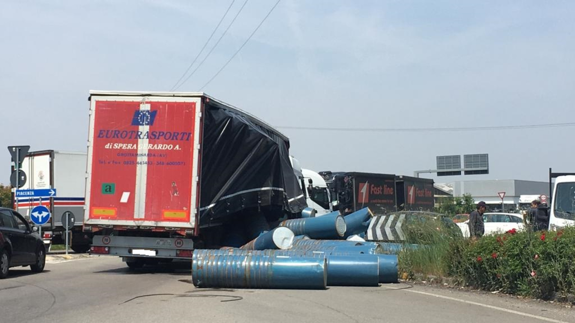 Camion perde il carico alla rotonda di Gariga: fusti sulle auto in sosta