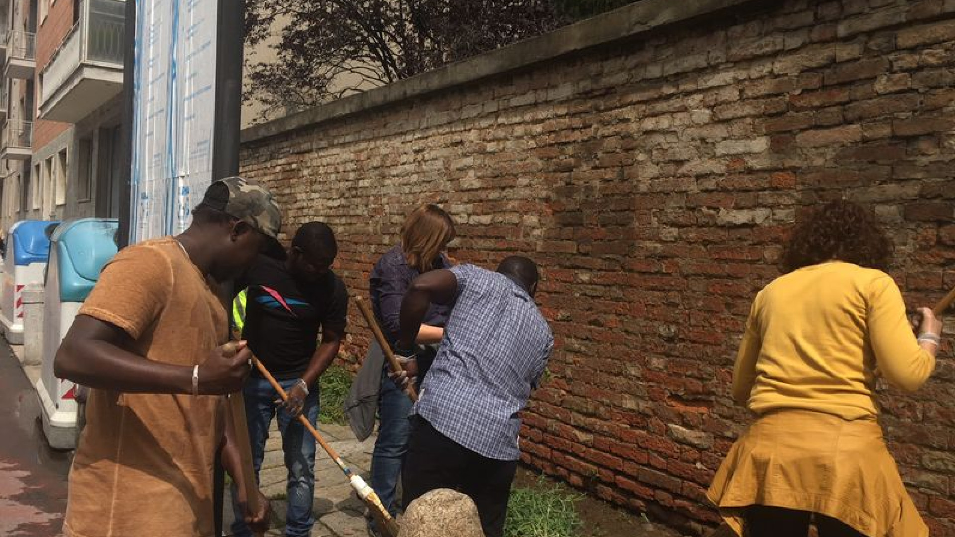 Richiedenti asilo puliscono i marciapiedi dello Stradone Farnese dalle erbacce