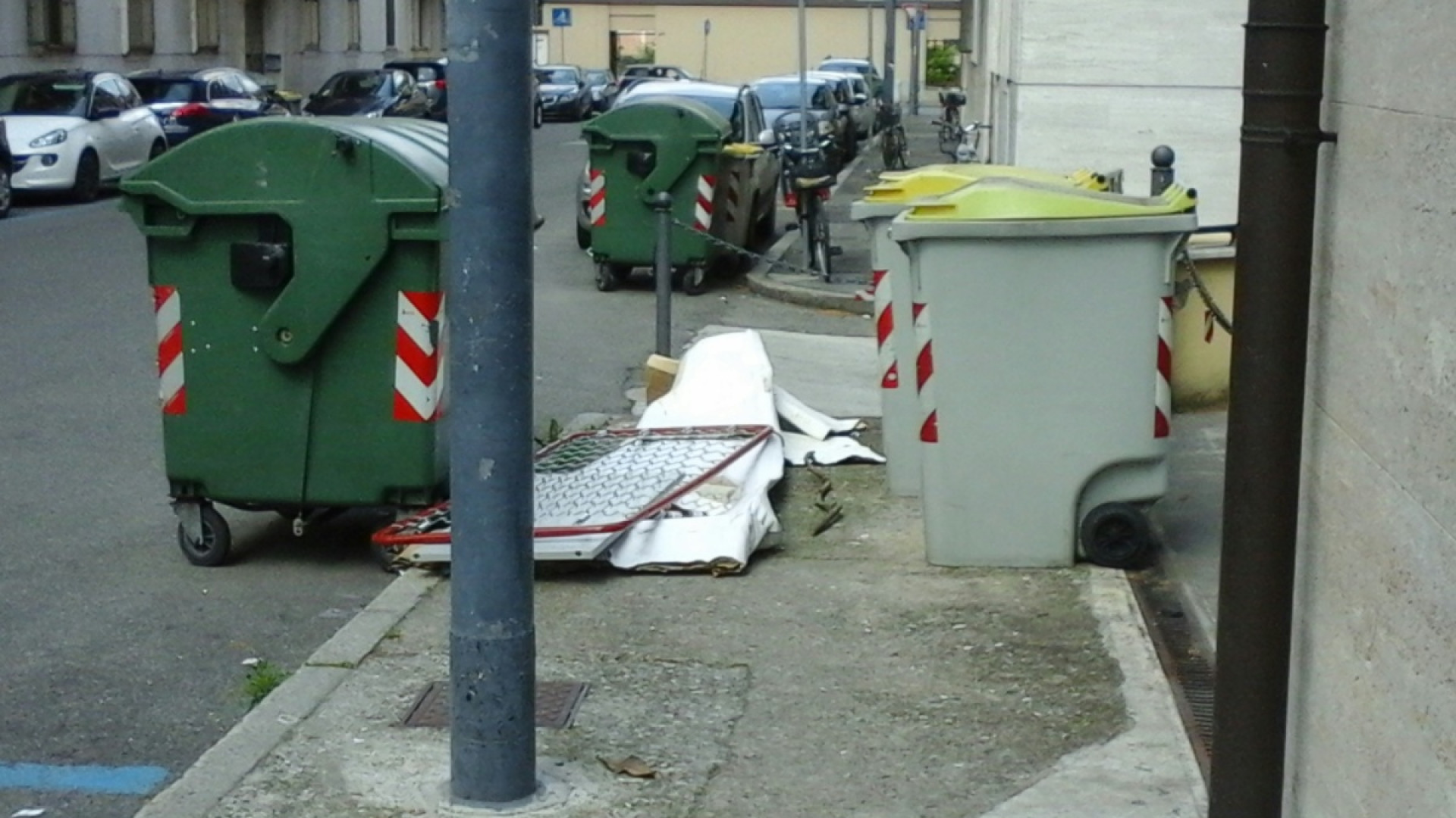 Degrado in città, rete da materasso abbandonata sul marciapiede