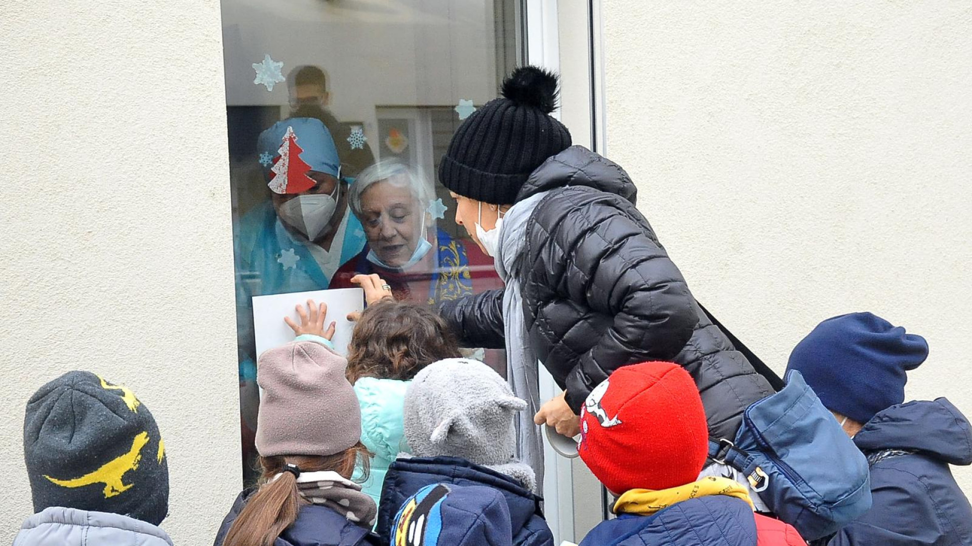 Le mani dei bimbi sulle finestre scaldano il cuore degli anziani: “Buon Natale”