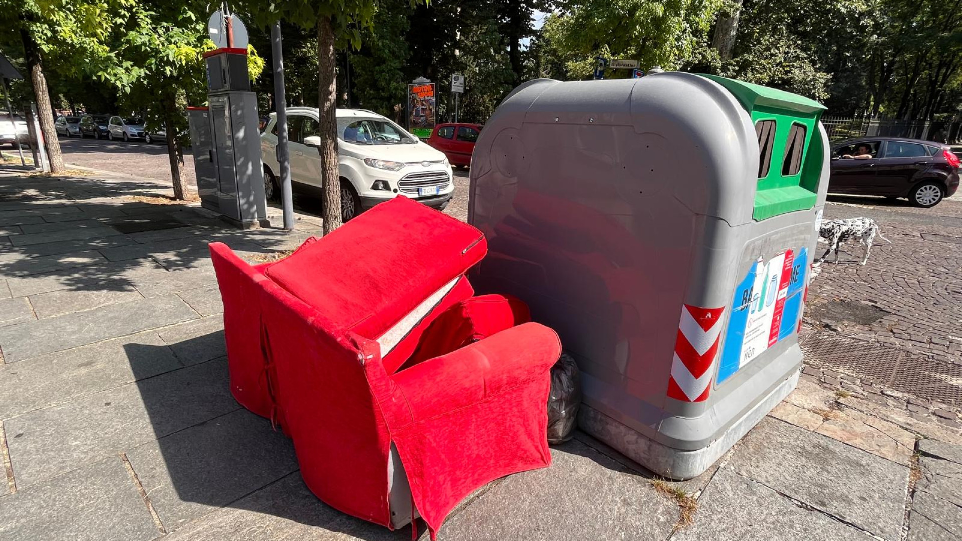 Inciviltà in via Giarelli a Piacenza: divano rosso abbandonato a cielo aperto